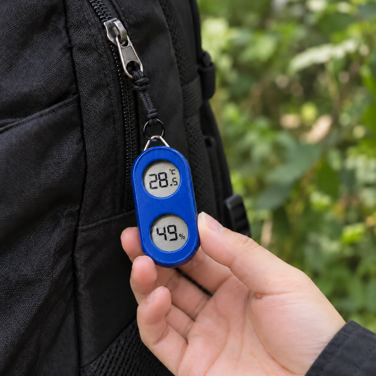 Blue TH05B thermometer and hygrometer hanging from a backpack
